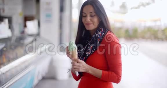 吃冰淇淋蛋卷的漂亮年轻女人视频的预览图