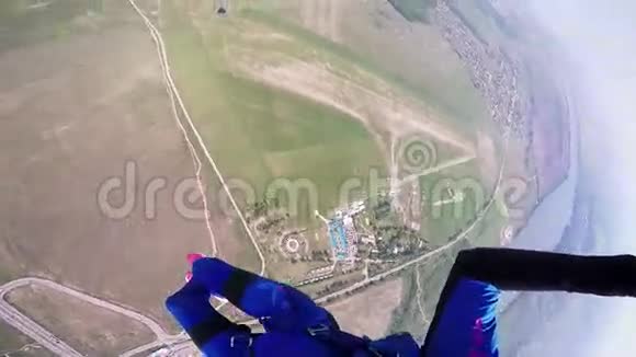 专业的跳伞运动员在绿色的平坦地带河流上空飞行蓝色西装景观视频的预览图