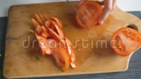 在家厨房里女人用手在木板上切红番茄做披萨视频的预览图
