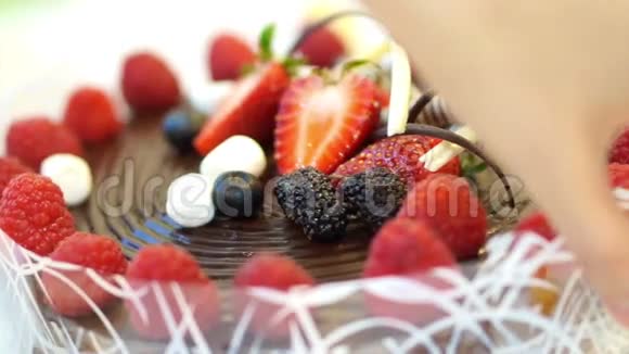 带有新鲜草莓和浆果的粘粘巧克力蛋糕视频的预览图