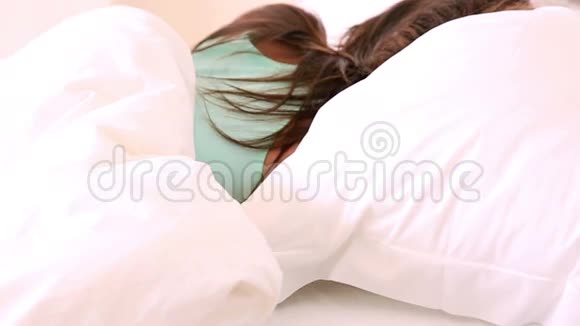 熟睡的黑发女人在床上翻滚视频的预览图