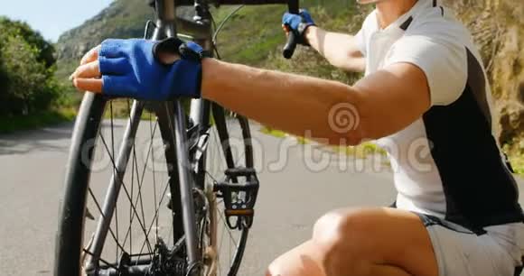 高级骑自行车者在乡村检查自行车视频的预览图