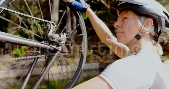 高级骑自行车者在乡村检查自行车视频的预览图