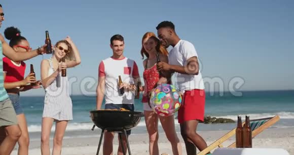 年轻的成年朋友在海滩上烧烤4k视频的预览图