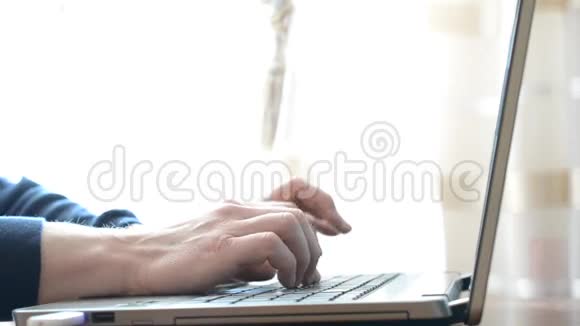 身材苗条的男人手在家里用笔记本电脑快速打字视频的预览图