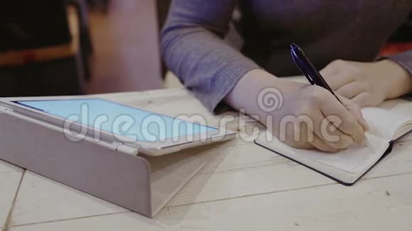 女人在笔记本上做笔记就在附近的触摸板上视频的预览图
