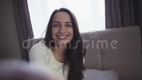 迷人的少女正在做一张脸和微笑的自拍照片视频的预览图