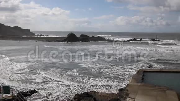 英国北部康沃尔郡北部博斯卡斯特的一个刮风的日子有海浪和冲浪者很受冲浪板的欢迎视频的预览图