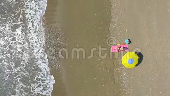 艾琳漂亮的年轻女人在海滩上晒日光浴视频的预览图