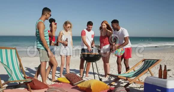 年轻的成年朋友在海滩上烧烤4k视频的预览图