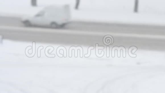 冬天下雪了汽车在白雪覆盖的道路上行驶视频的预览图