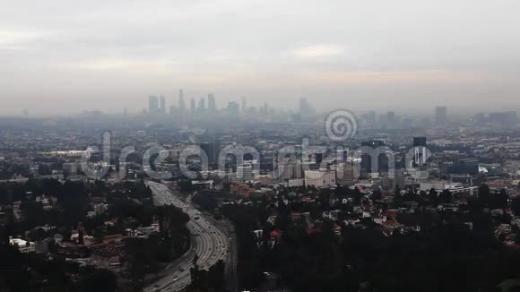 俯瞰洛杉矶市中心的暮色前景是一条繁忙的高速公路视频的预览图