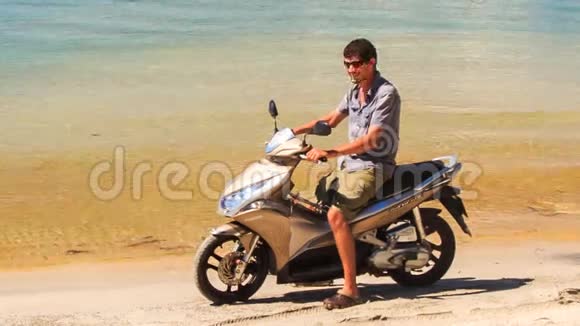 骑摩托车的特写镜头开始沿着海滩行驶视频的预览图