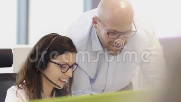 在呼叫中心办公室工作的员工带着耳机视频的预览图