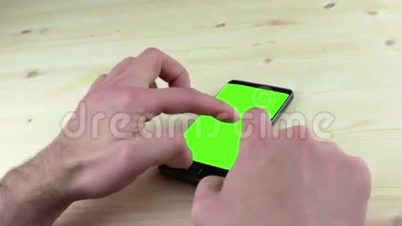 男人用智能手机写带有色度键的短信白色背景的绿色屏幕视频的预览图