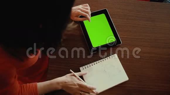 在平板电脑上工作的女人笔记本上的草图绿色屏幕视频的预览图