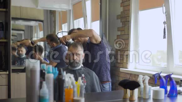 时尚的Barber负责理发年老的客户留着白发和胡须视频的预览图