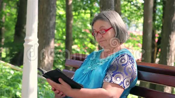 在公园里读圣经的老妇人视频的预览图