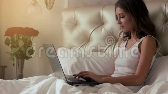 在床上工作的年轻女子视频的预览图