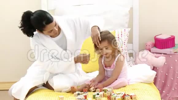 妈妈在床上和女儿们玩玩具方块视频的预览图