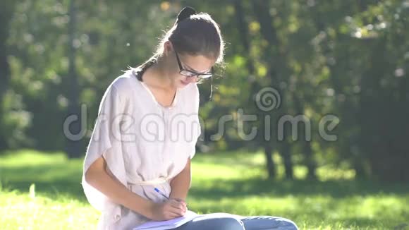 在公园里听音乐和使用智能手机的年轻女性视频的预览图