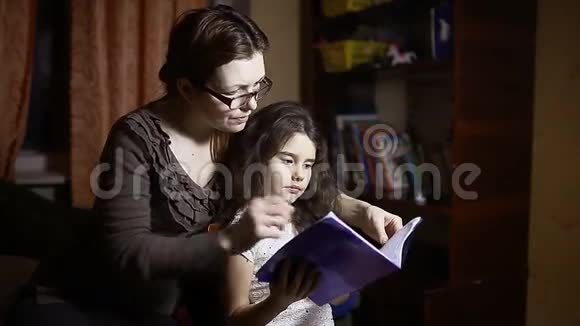 妈妈和女儿晚上在房间里看书健康的生活方式视频的预览图