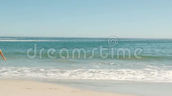 金发女人在海滩上跳跃视频的预览图