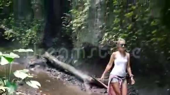 沿着热带雨林中的小路步行到瀑布巴厘视频的预览图