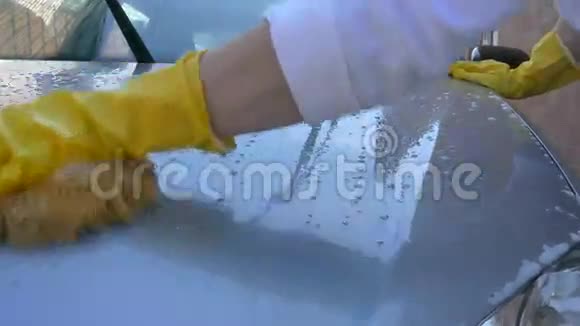 戴着黄色手套的女人在洗车视频的预览图