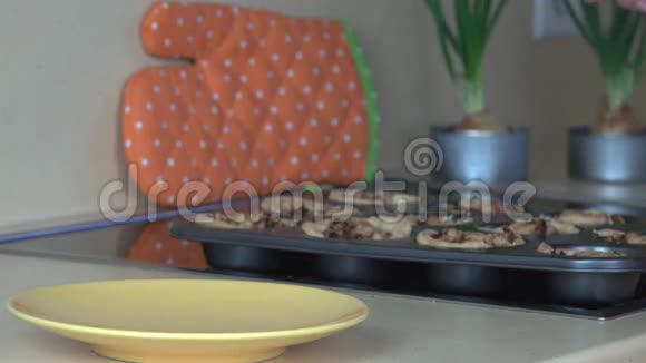 面包师把烤好的肉杯饼从饼盘里拿出来放进盘子里视频的预览图