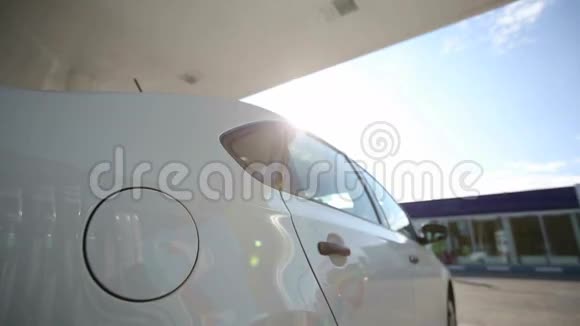 日出时一个男人把白色的汽车质量的生物燃料装满视频的预览图