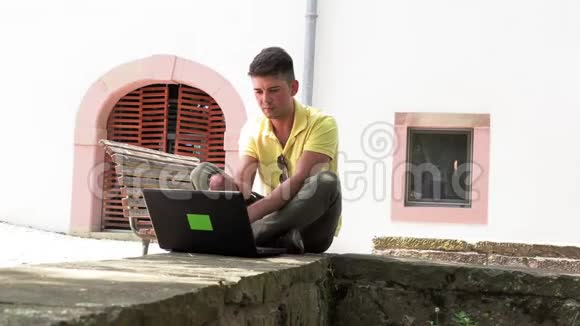 一个年轻的青少年在用手提电脑视频的预览图