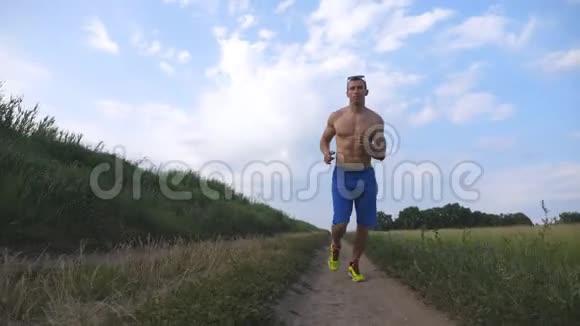 肌肉男在乡间小路上奔跑年轻的运动员在乡间小道上慢跑男运动员训练视频的预览图
