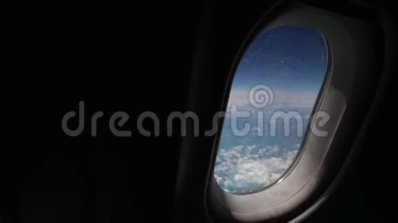 透过飞机的窗户观看蓝天和云彩用飞机的翅膀关闭飞机的窗户视频的预览图