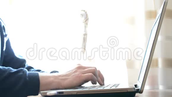 年轻苗条的男子手在家里用手提电脑打字视频的预览图