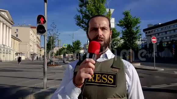 专业记者住在市街一个穿着特殊服装的记者走过城市的街道视频的预览图