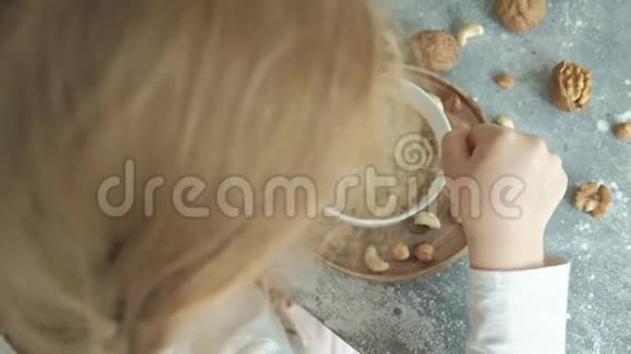 小可爱的女孩早餐吃燕麦片和坚果和干果健康食品概念视频的预览图