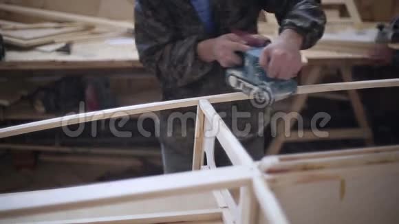 一个木匠在船厂打磨一块木头视频的预览图
