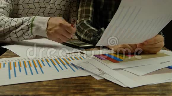 一张桌子上的数据商人和女商人的手关门视频的预览图