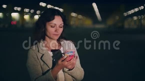 年轻女子在夜城的背景下打电话视频的预览图