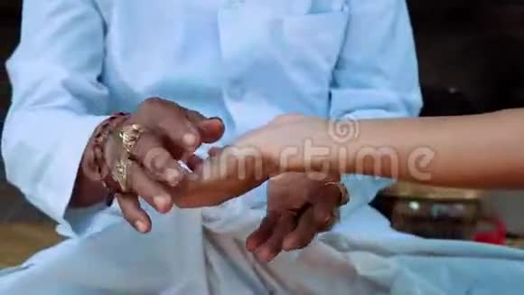 巴厘岛牧师牵着女人的手做手掌阅读视频的预览图