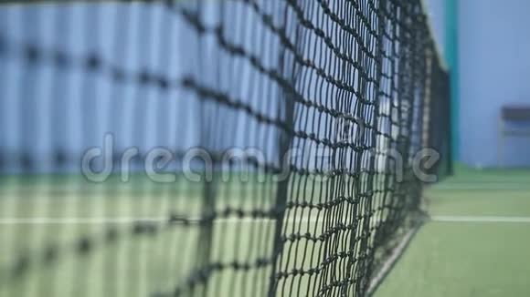 网球在晴天落在网球场上的球网上慢动作视频的预览图