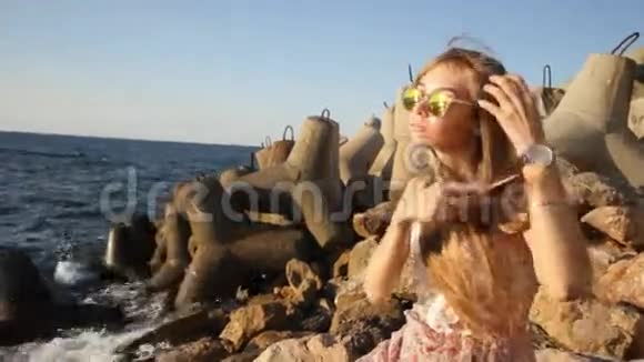迷人的微笑女人在海滨梳头视频的预览图