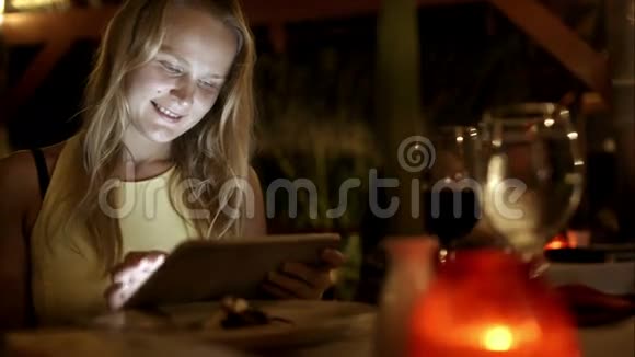 在度假村的餐厅里使用平板电脑的女人视频的预览图