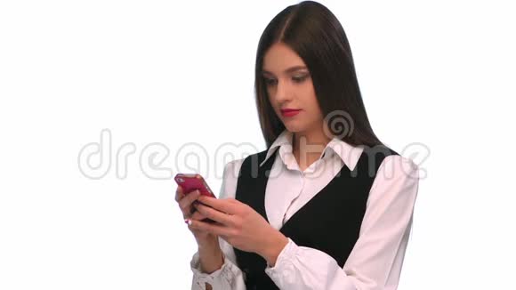 孤立背景下用手机发短信的年轻女子视频的预览图