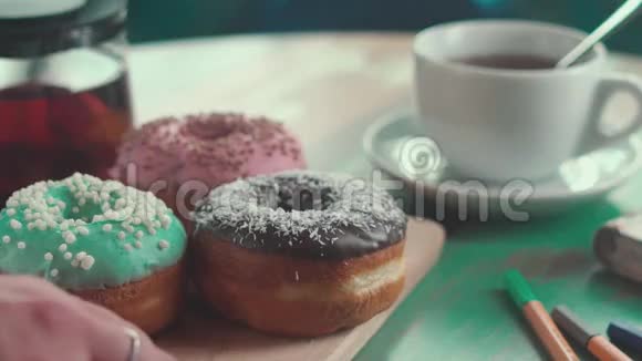 五颜六色的甜甜圈在空中结冰茶和甜甜圈视频的预览图