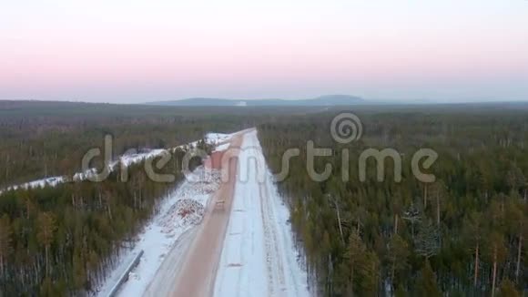 在清澈的冬季景观背景下半卡车在土路上的空中拍摄视频的预览图