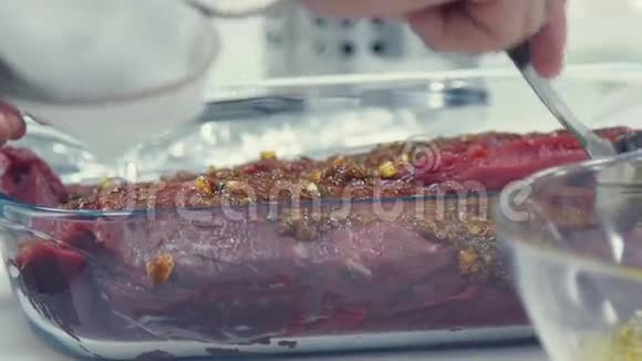 生肉在一个透明的难熔菜肴腌制香料视频的预览图
