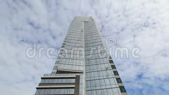 窗户反射4k的高耸玻璃塔楼上空白云的时间推移视频的预览图