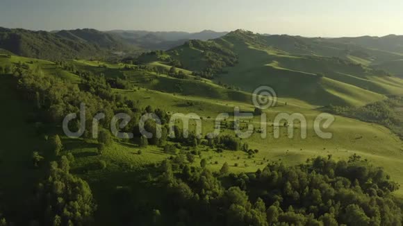 空中无人机镜头在日出的柔和光线下飞越森林田野和河流的秋山村视频的预览图